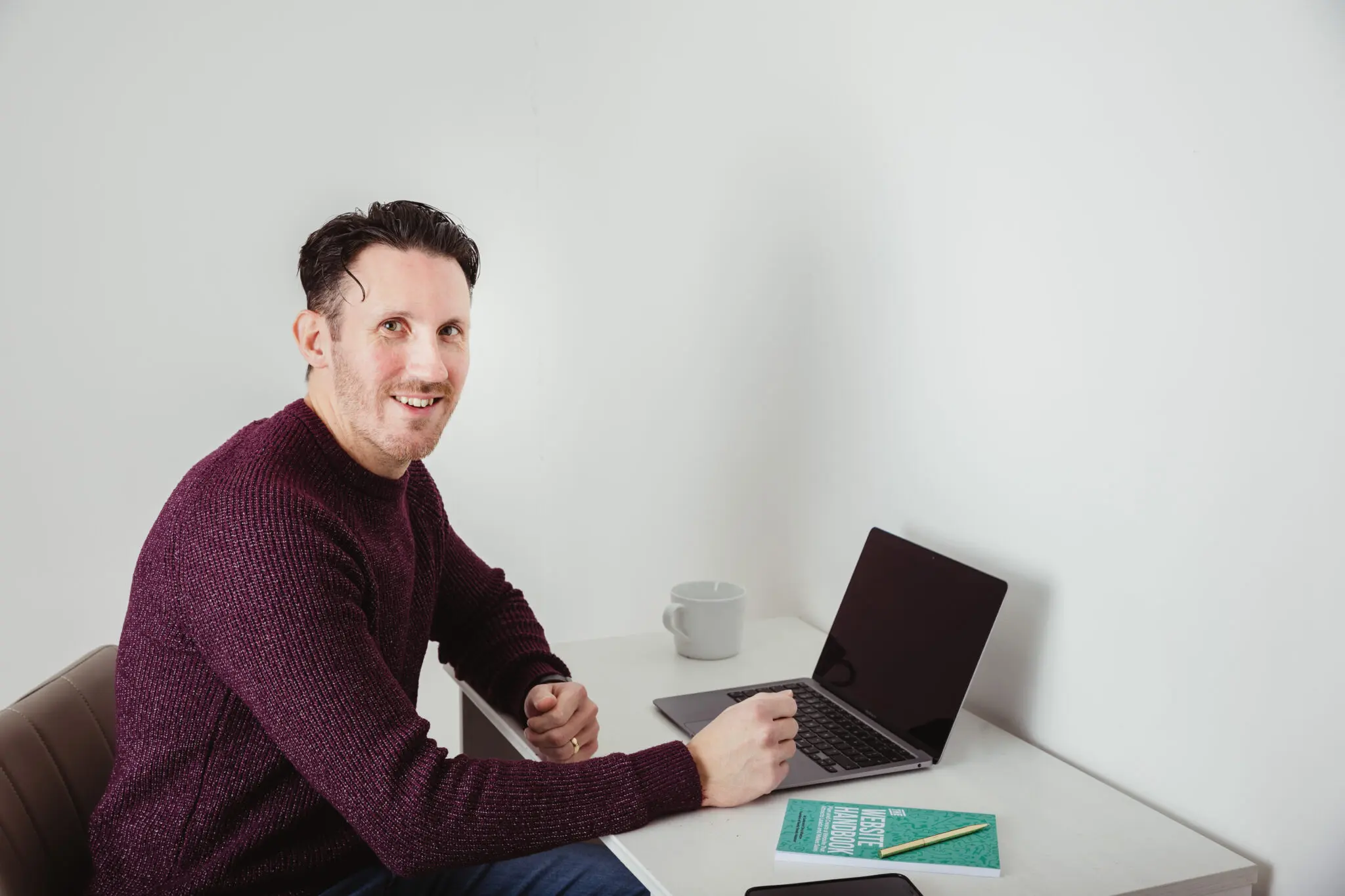 Chris Wharton sitting at a desk with his laptop