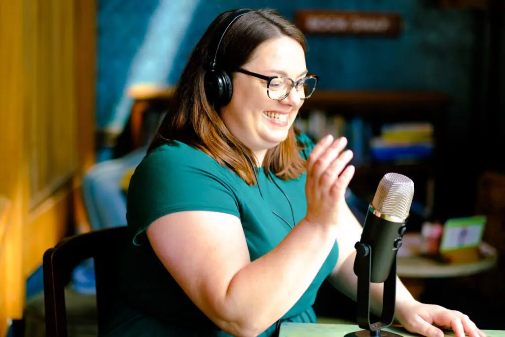 woman recording a podcast with a mic and headphones on
