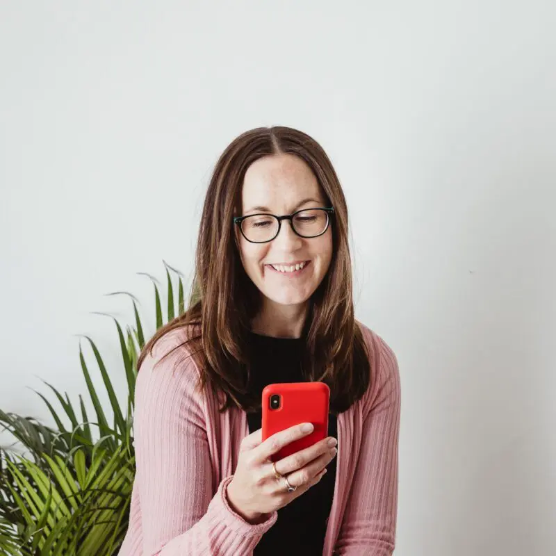 Jude Wharton smiling and looking at phone