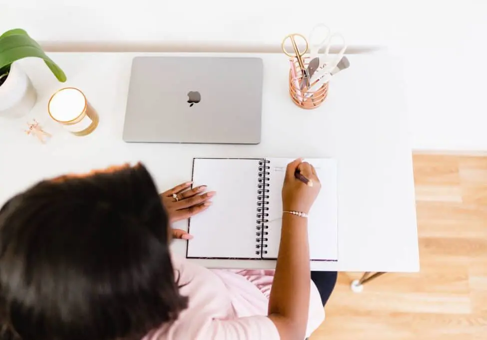 Woman writing in a planner at a desk
