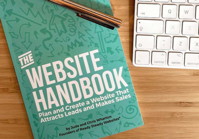 The Website Handbook on a desk with laptop and pen