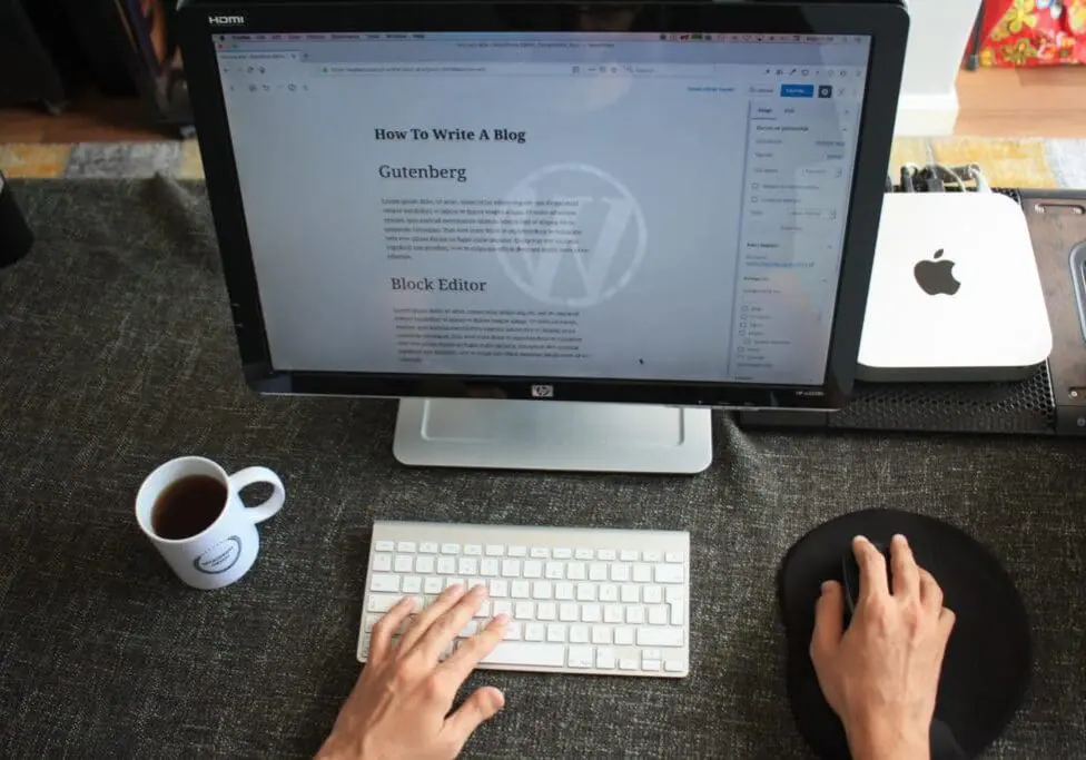laptop with website content on next to a coffee cup
