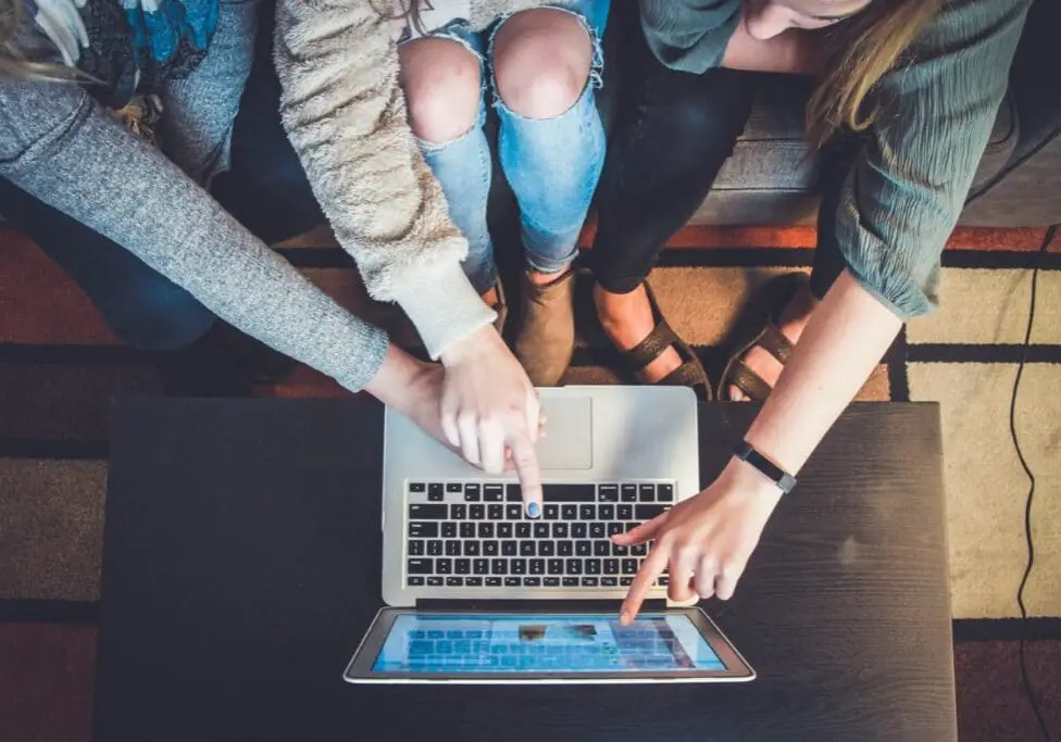 hands pointing to a laptop screen