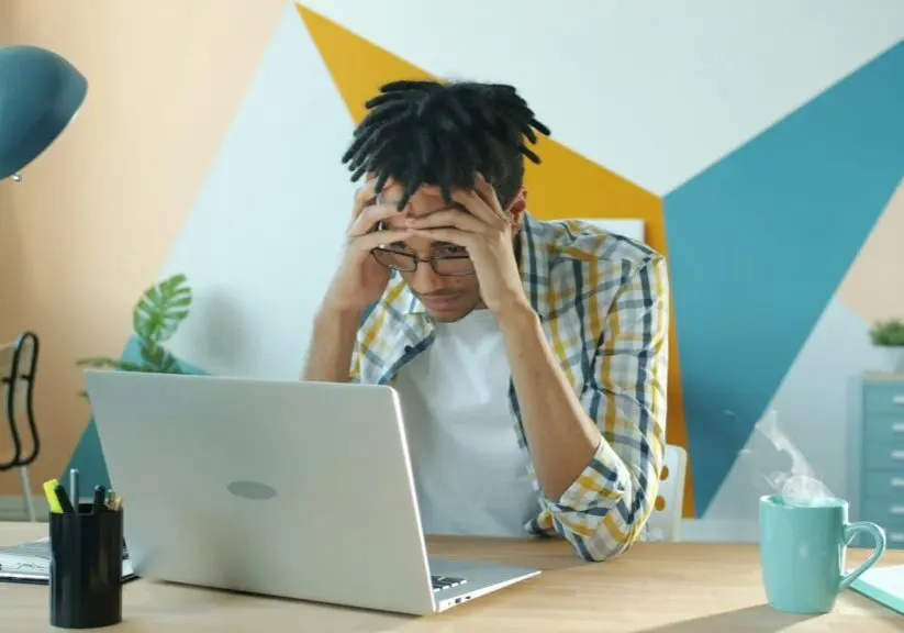 man frustrated at laptop