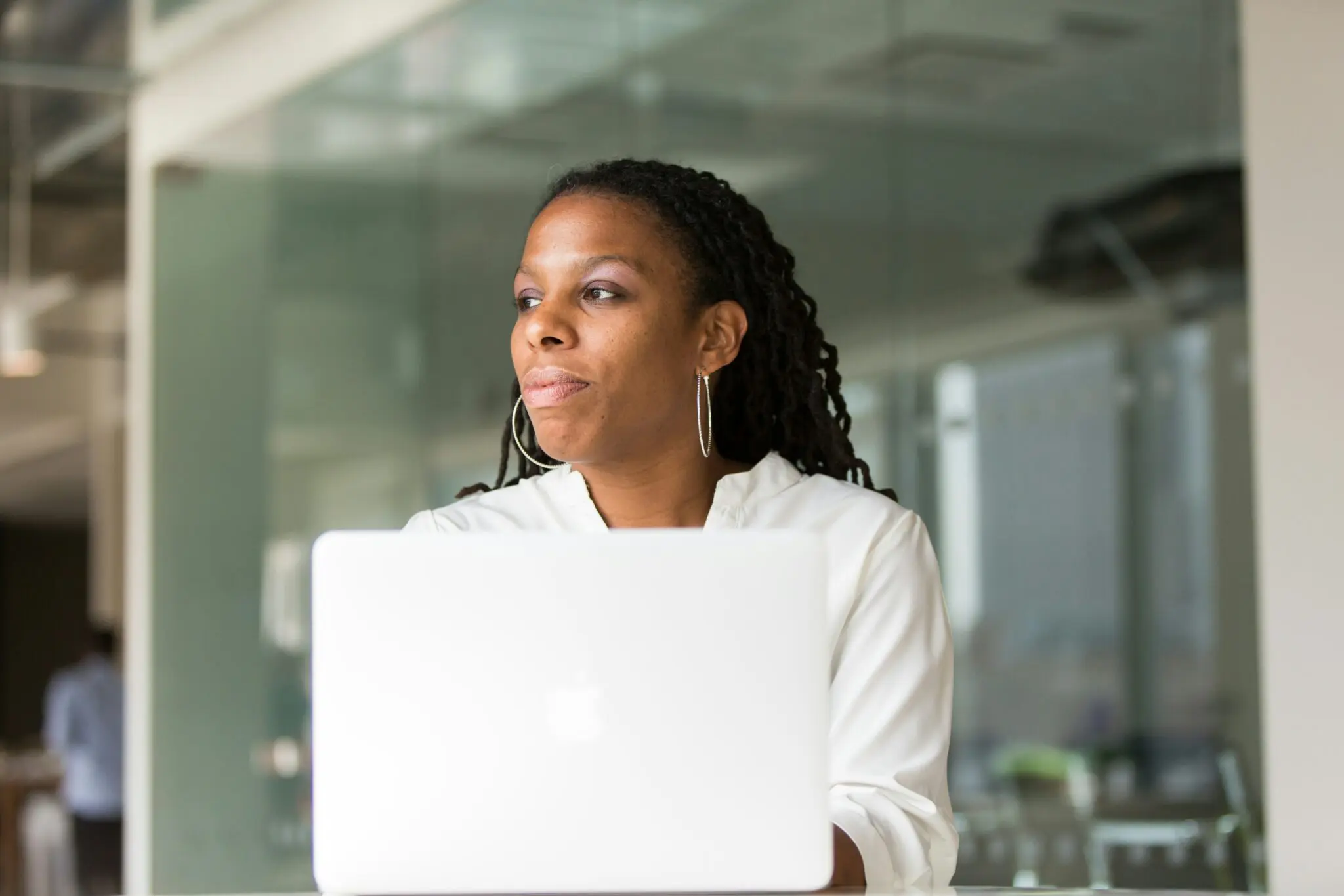 woman thinking while working on her website at laptop