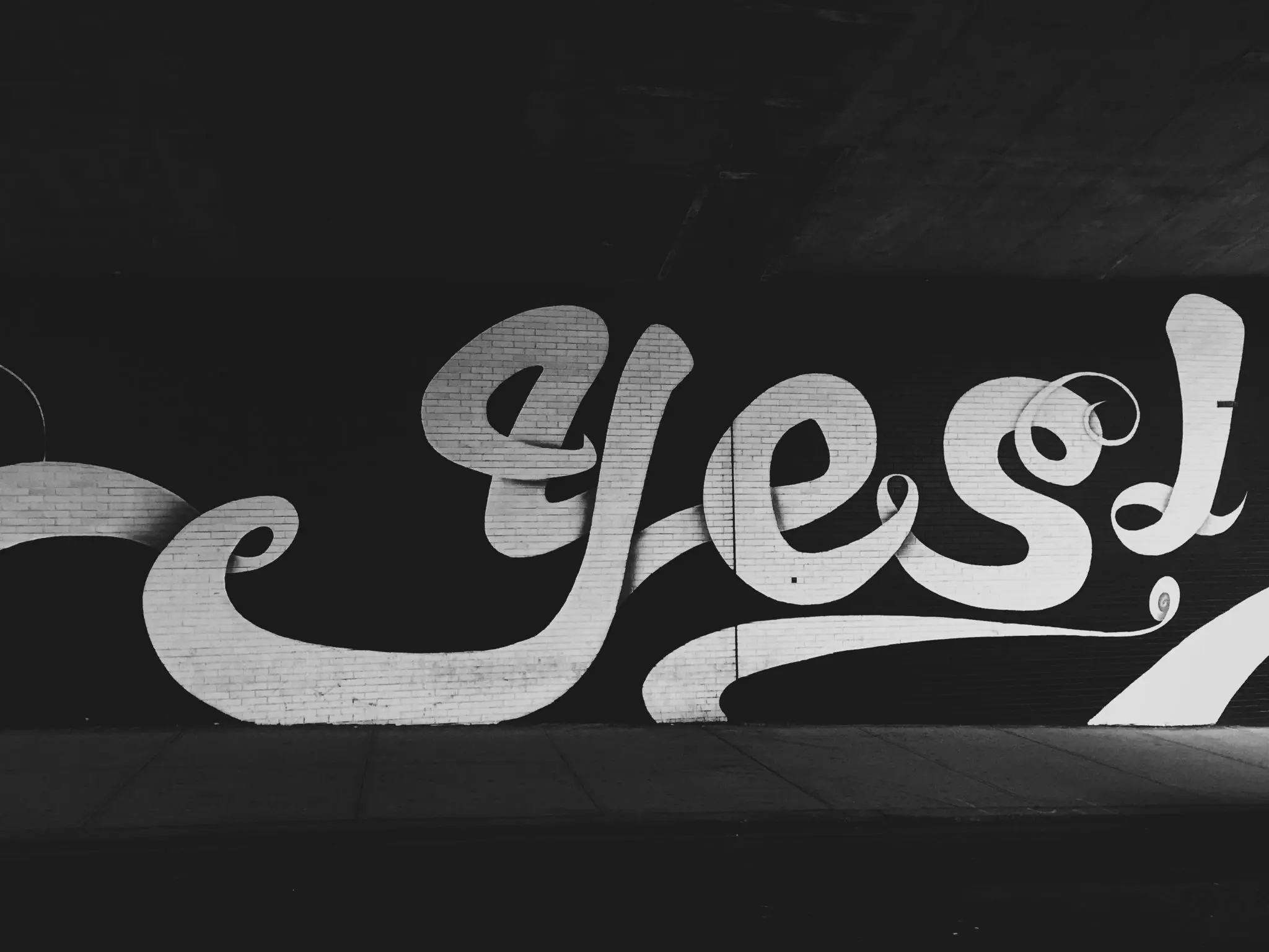 Yes written on a wall in hand lettering