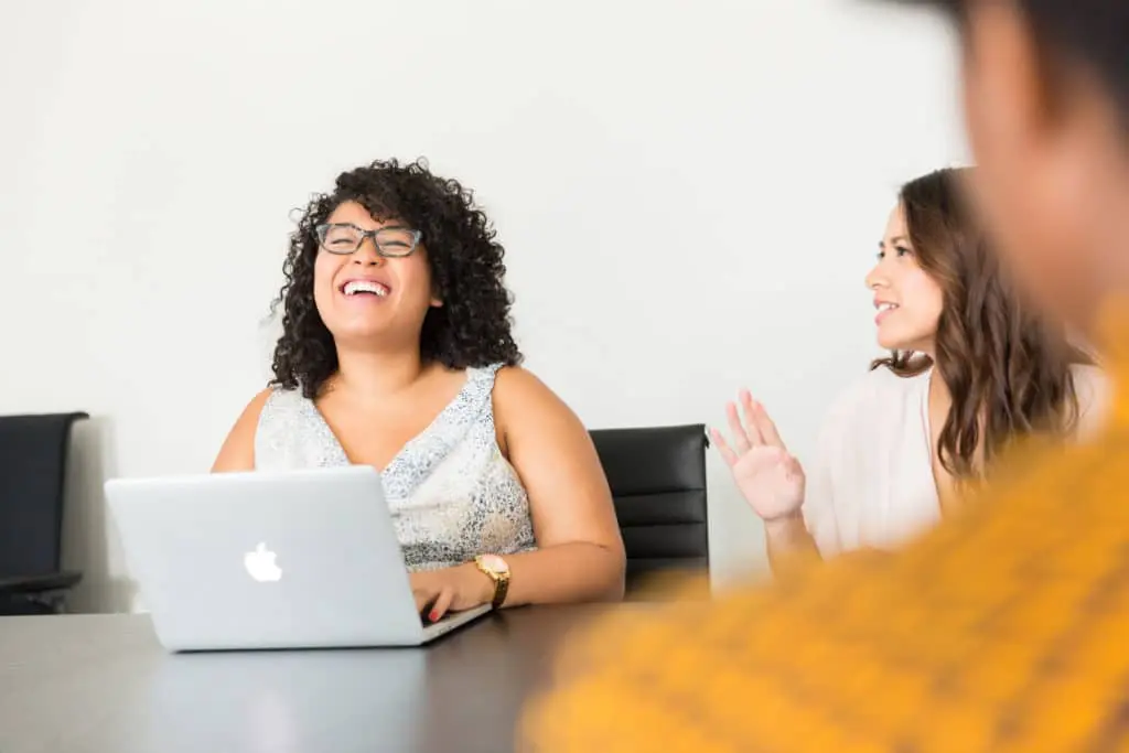 Woman laughing in front of laptop