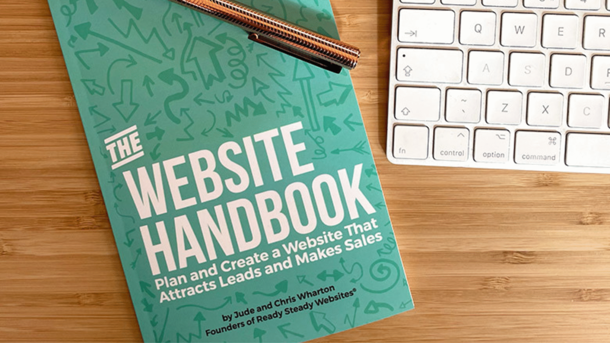 The Website Handbook on a desk with laptop and pen