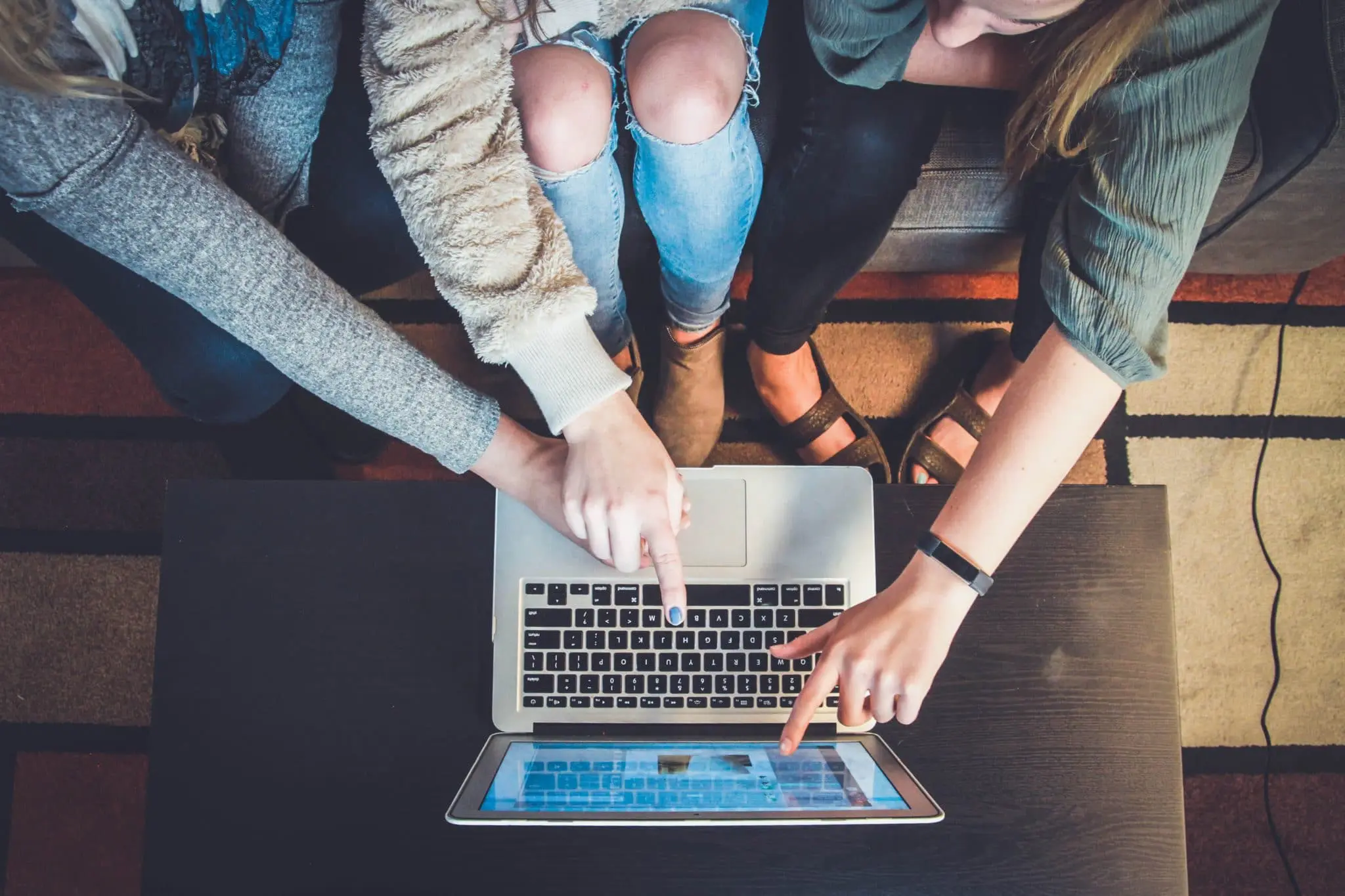 hands pointing to a laptop screen