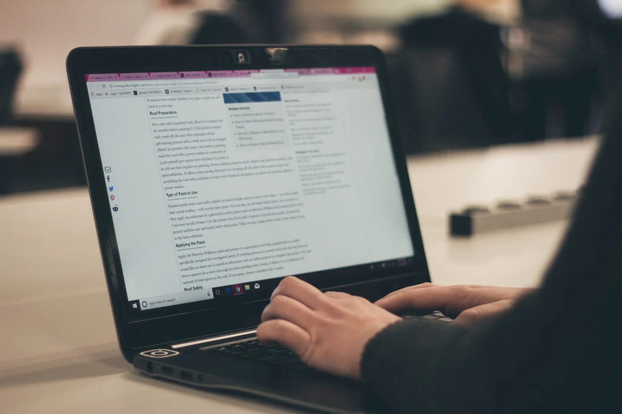 Blog post on screen with hands on laptop