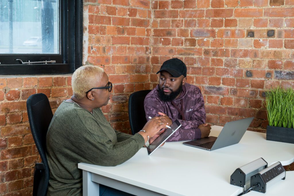 Two people working together at a desk getting support in their business