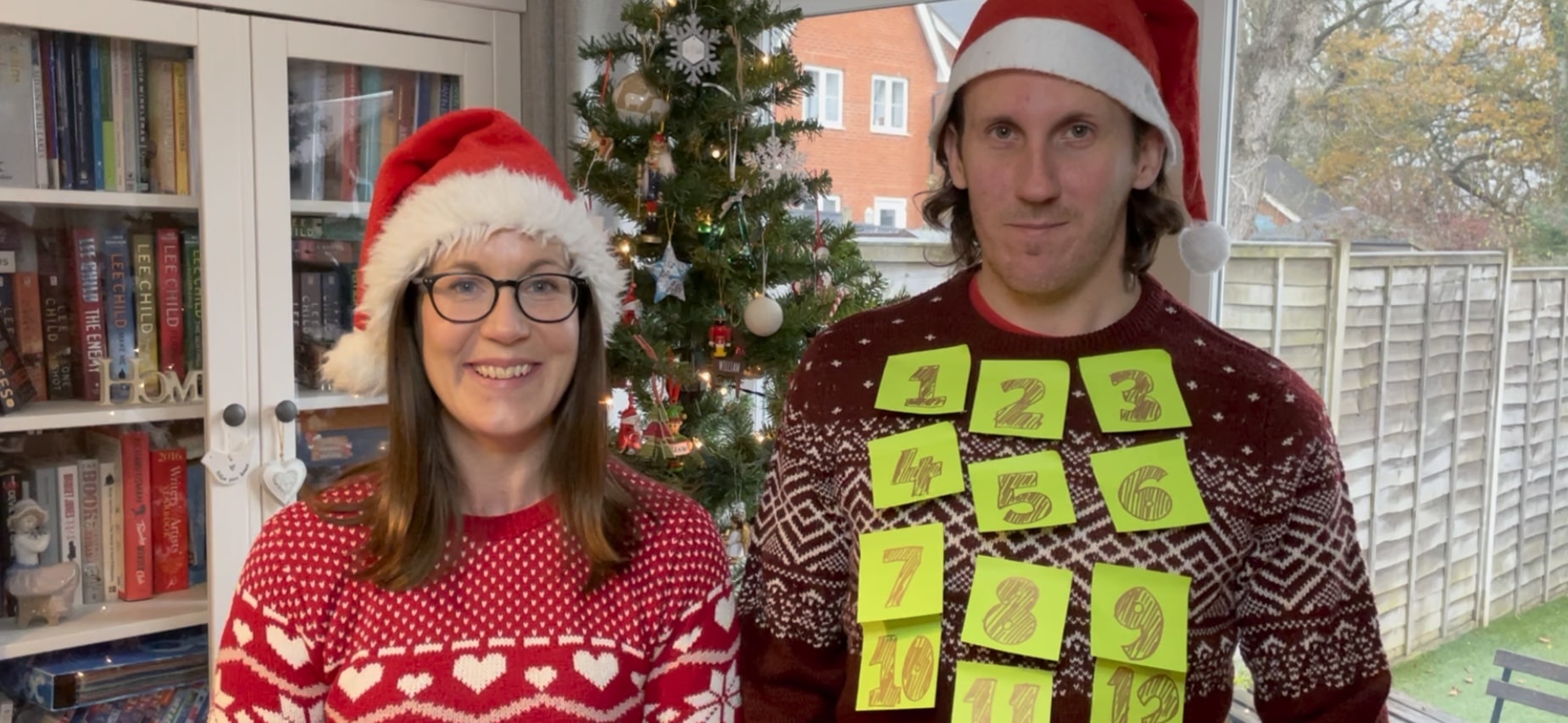 Jude and Chris in Christmas jumpers and hats smiling Thank you