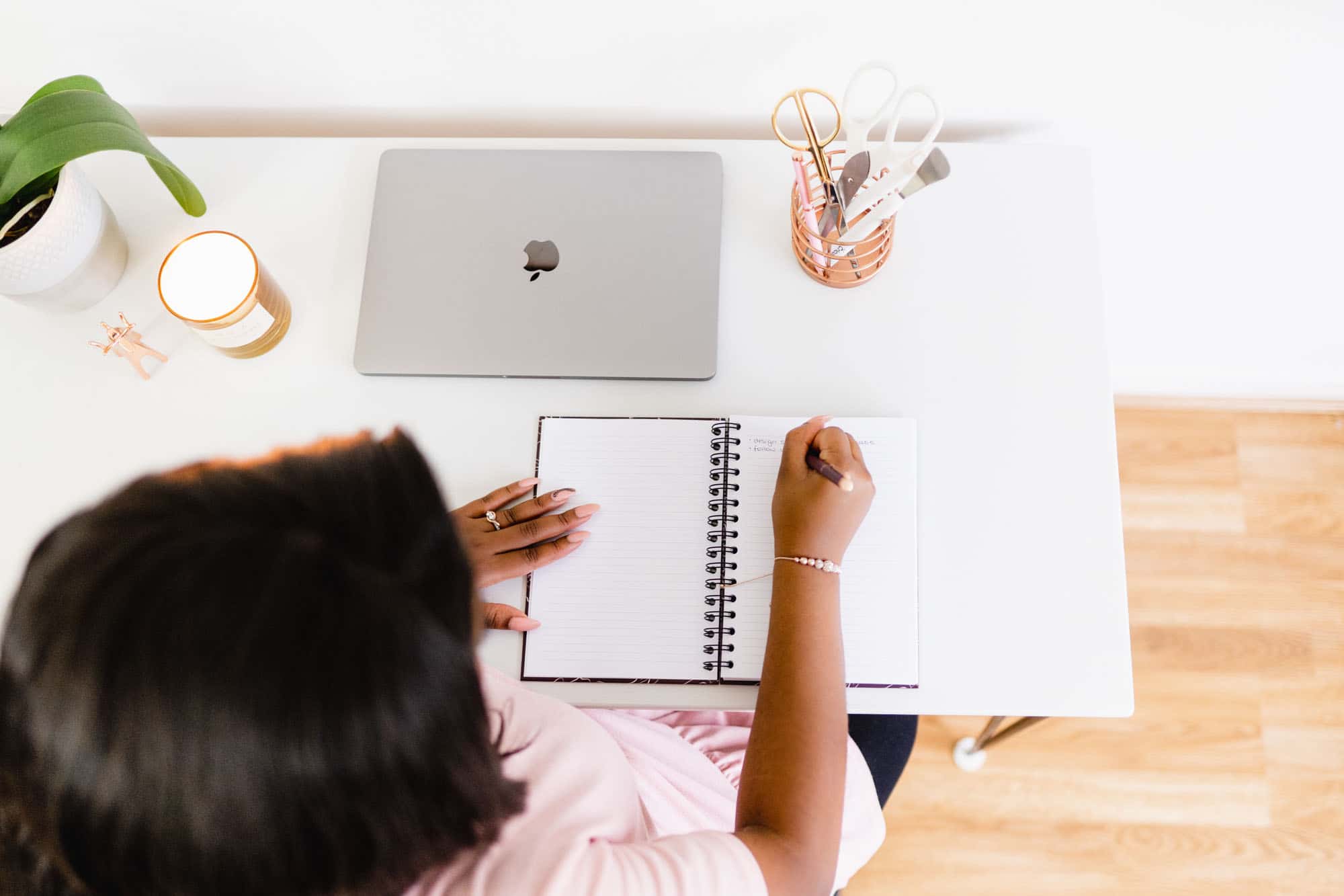 Woman writing in a planner at a desk