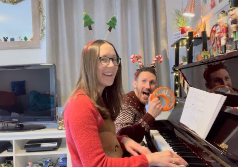 Chris and Jude from Ready Steady Websites® at a piano wearing Christmas jumpers and novelty headbands