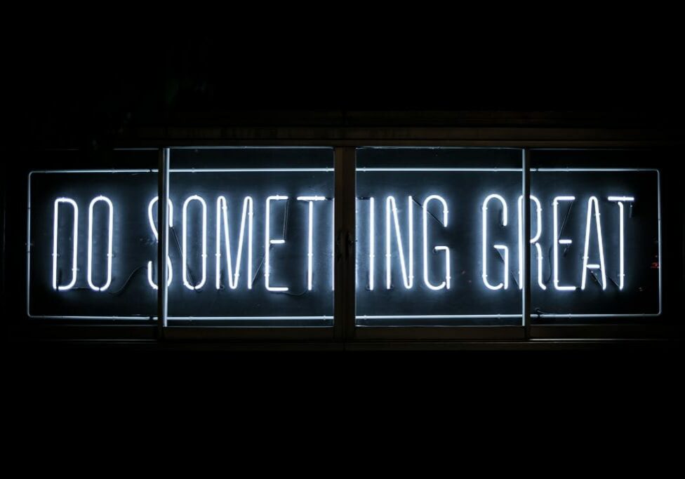 "Do something great" written in lights, with a view through a window