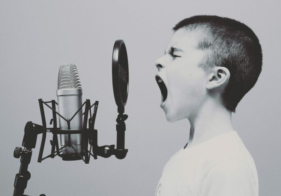 Boy shouting into mic checking his tone of voice