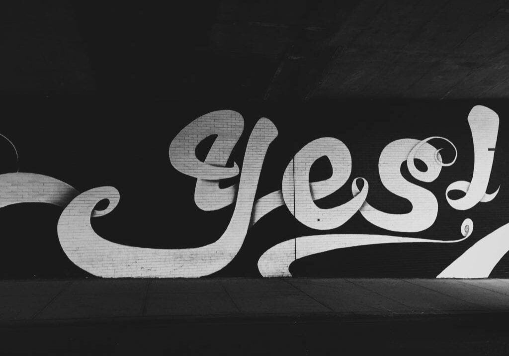 Yes written on a wall in hand lettering