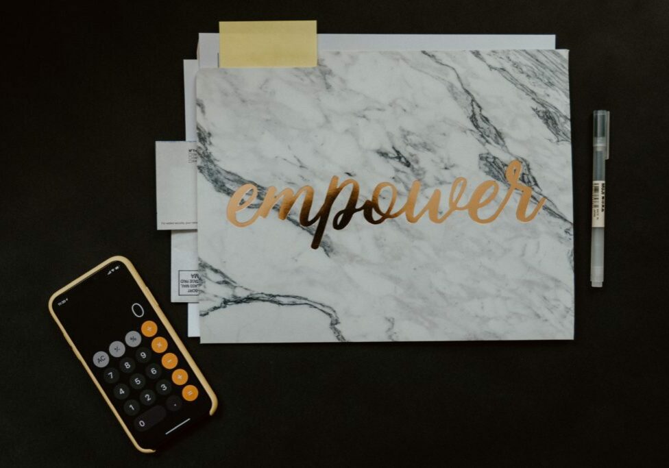 Calculator and notebook with "empower" written on it