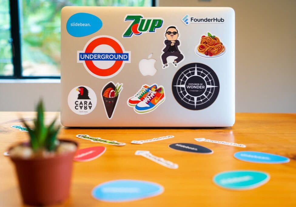 Laptop with lots of stickers on it, on a desk
