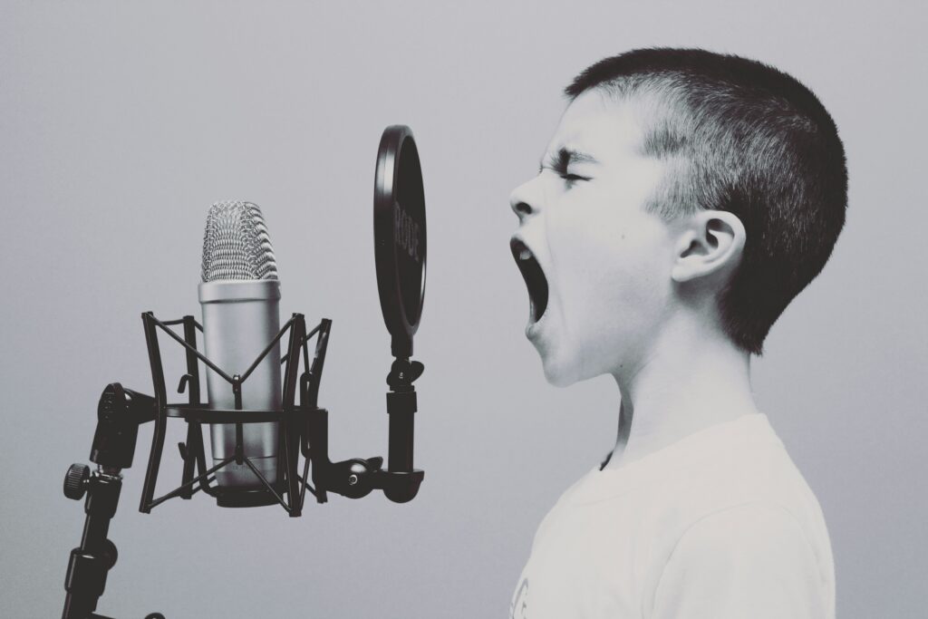 Boy shouting into mic checking his tone of voice
