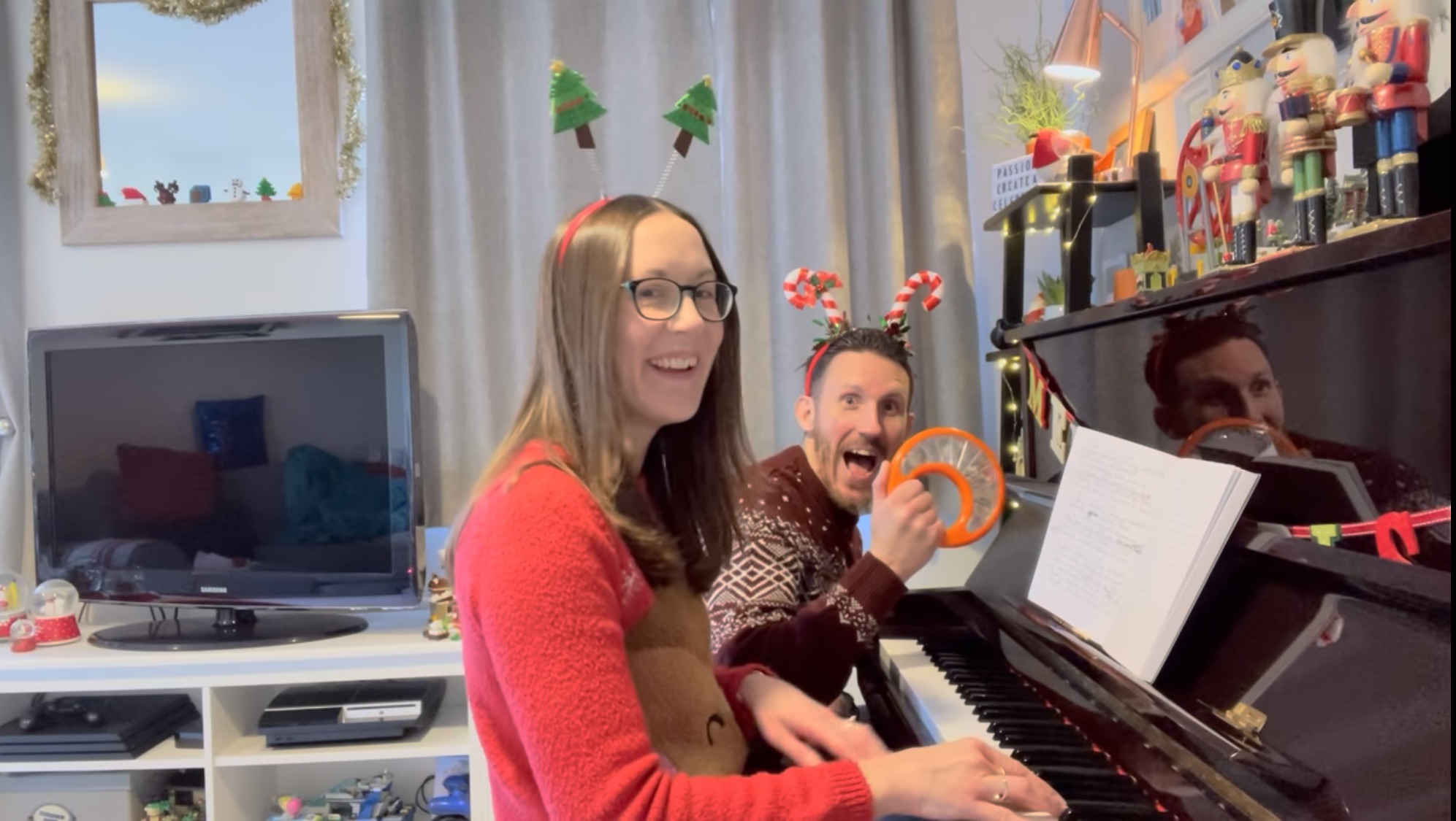 Chris and Jude from Ready Steady Websites® at a piano wearing Christmas jumpers and novelty headbands